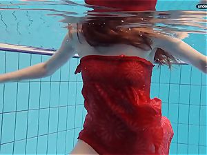 red clothed teenage swimming with her eyes opened